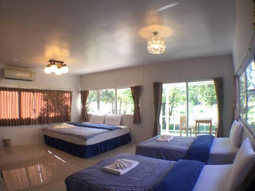 a bedroom with two beds and a couch at Baan Pai Riverside Resort in Pai