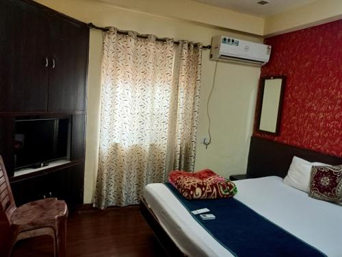 um quarto de hotel com uma cama e uma televisão em Hotel Geetanjali St Bus Stand Panvel em Panvel