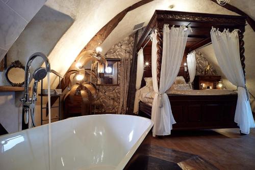 een badkamer met een bad en een bed bij Manoir de la Sénéchaussée de Lantiern in Arzal