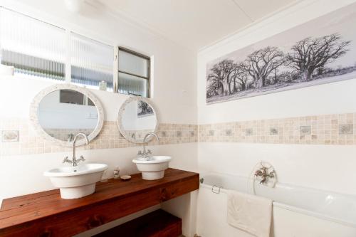 a bathroom with two sinks and a tub and mirrors at Naos Farm Stay 