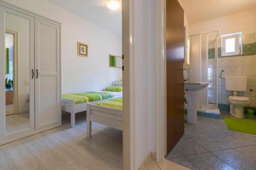 1 dormitorio con cama, lavabo y aseo en Apartman Maša, en Dramalj