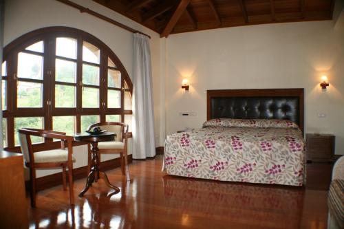 a bedroom with a bed and a desk and a table at Hotel Valle Las Luiñas in Soto de Luiña