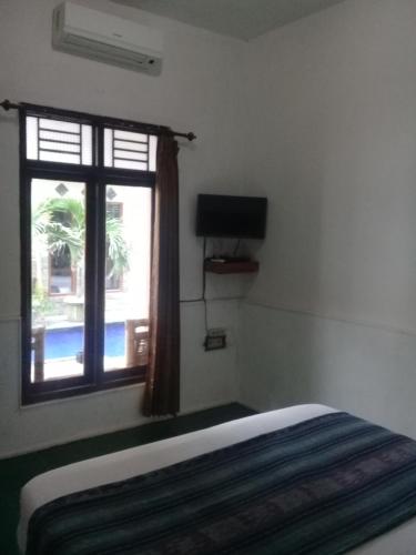 - une chambre avec un lit et une fenêtre dans l'établissement Wahyu Gili 1, à Gili Trawangan