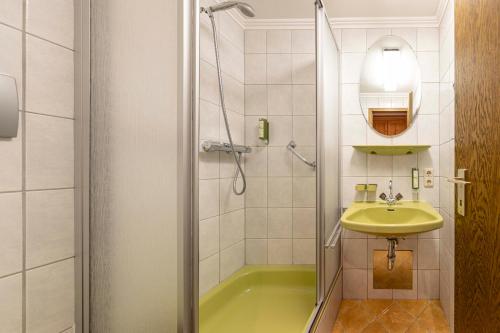 a bathroom with a green tub and a sink at Dorfresort Kitzbühel by ALPS RESORTS in Reith bei Kitzbühel
