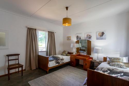 a bedroom with two beds and a desk and a mirror at Naos Farm Stay 