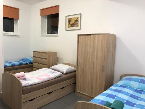 a bedroom with two twin beds and a cabinet at Penzión Radlinka in Prešov