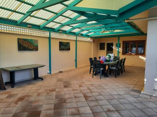 a room with a ping pong table and chairs at Cottage by the Sea in Port Adelaide
