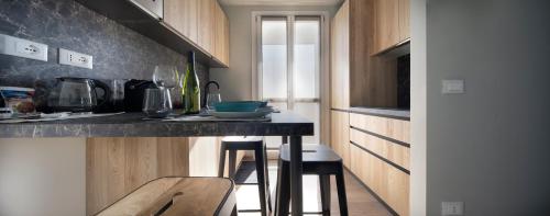 a kitchen with a counter with stools in it at New San Raffaele Apartment with Free Parking and Air Conditioning in Segrate