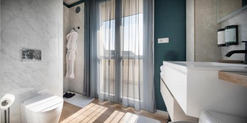 a bathroom with a white toilet and a sink at New San Raffaele Apartment with Free Parking and Air Conditioning in Segrate
