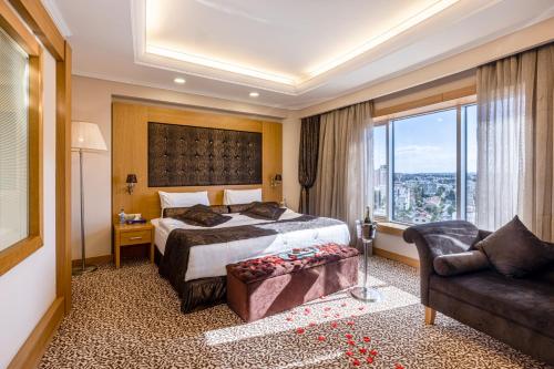 a hotel room with a bed and a couch at Grand Pasha Lefkosa Hotel & Casino in North Nicosia