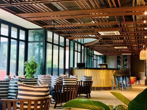 een restaurant met stoelen en een bar met ramen bij Glese Balcony Seaview Apartment - FLC Sea Tower Quy Nhon in Quy Nhon