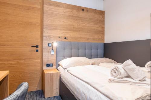 a bedroom with a large bed with a wooden headboard at Dorfresort Kitzbühel by ALPS RESORTS in Reith bei Kitzbühel