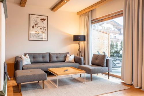 a living room with a couch and a table at Dorfresort Kitzbühel by ALPS RESORTS in Reith bei Kitzbühel
