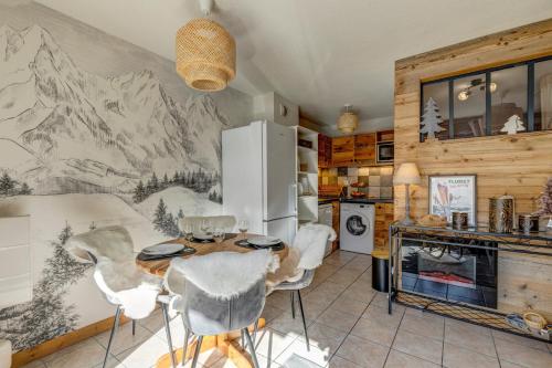 une cuisine avec une table, des chaises et un réfrigérateur dans l'établissement Le Flocon de Neige - Appt cosy avec terrasse, à Flumet