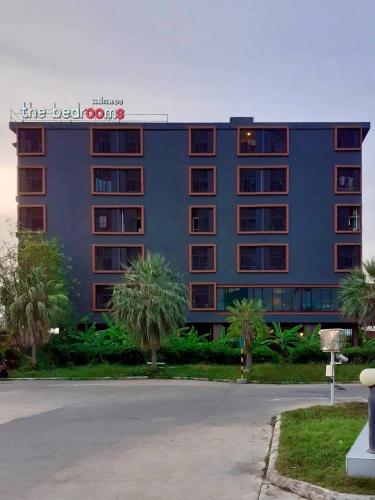 a large blue building with a sign on it at The Bedrooms Maeklong and Services Apartment in Samut Songkhram
