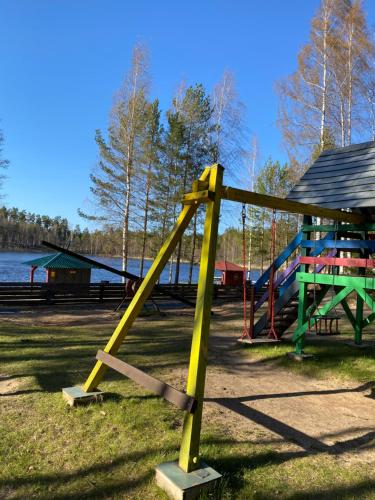 a playground with a yellow slide in a park at Kempings Bejas in Babīte