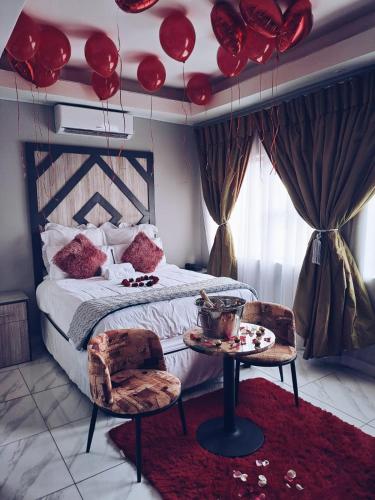 a bedroom with a bed with red balloons on the ceiling at National Lodge in Benoni