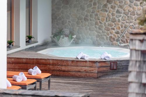 a jacuzzi tub in a room with a stone wall at Dorfresort Kitzbühel by ALPS RESORTS in Reith bei Kitzbühel