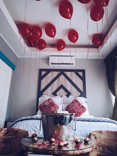 a room with a bed with red balloons hanging from the ceiling at National Lodge in Benoni