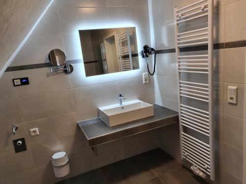 a bathroom with a sink and a mirror at Krokusstr. 27A, Norden-Norddeich in Norden