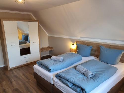 a bedroom with two beds with blue pillows at Krokusstr. 27A, Norden-Norddeich in Norden