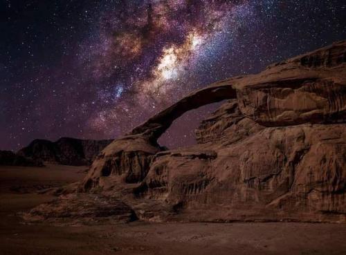 a starry night with the milky way over a mountain at Flower Life Camp in Wadi Rum