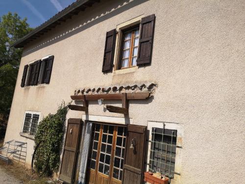 una casa con puertas marrones y ventanas. en Canto perdigal, en Caylus