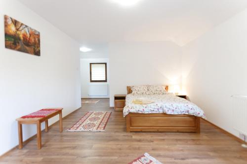 a bedroom with a bed and a table at Pensiunea Cașoca-Cascadă in Siriu