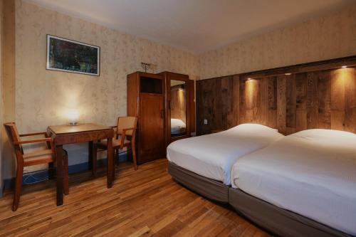 a bedroom with a bed and a desk and a table at Buitengoed De Uylenburg in Delft