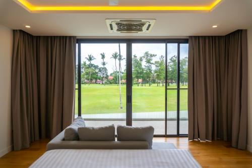 - un salon avec un canapé et une grande fenêtre dans l'établissement Laguna homes, à Thalang