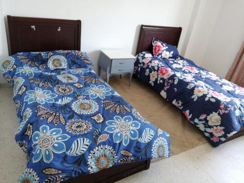 a bedroom with two beds with blue comforter at EZZAYATINE in Tunis