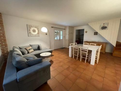 ein Wohnzimmer mit einem Sofa und einem Tisch in der Unterkunft Lauraguel Gîte in Mourvilles-Hautes