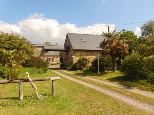 une maison avec un oiseau assis sur un banc à côté d'une route dans l'établissement Métairie L'Yvaël, à Crozon