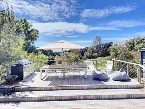 a wooden deck with a picnic table and an umbrella at Red Hill Lane 5BedroomVineyard&RuralValleyViews in Red Hill South