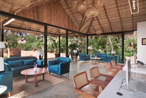 a large lobby with blue chairs and tables at LaRiSa Resort & Spa, Ashwem in Mandrem