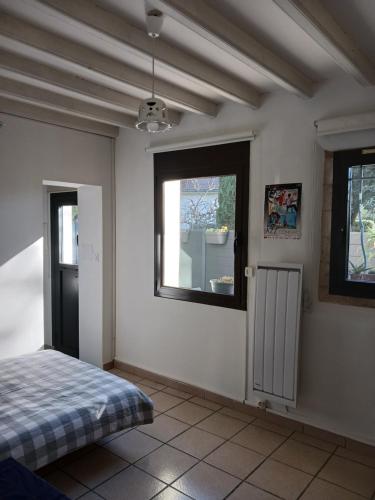 um quarto com uma cama e duas janelas em studio charmant et calme villeneuve les avignon entrée et cour indépendantes climatisation piscine parking em Villeneuve-lès-Avignon