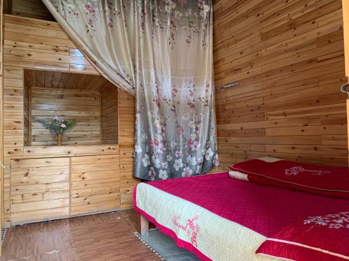 a bedroom with a bed in a wooden room at Vĩ Homestay in Lao Cai