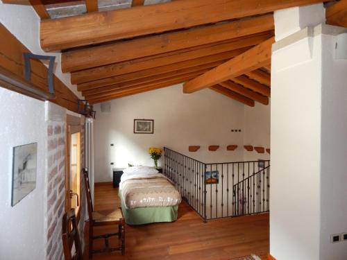 Romano D'EzzelinoにあるMonte Grappa Guest Houseの木製の天井の客室で、ベッドルーム1室(ベッド1台付)
