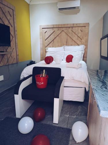 a bedroom with a bed with red and white pillows at National Lodge in Benoni