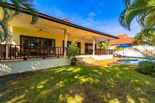 a house with a yard and a swimming pool at Cozy 3 Bedroom Pool Villa Close to Town - CV3L in Hua Hin