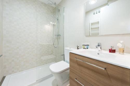a bathroom with a toilet and a sink and a shower at Apartamento con jardin privado y portero (A) in Madrid