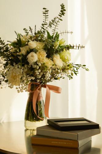 a vase filled with flowers sitting on top of a book at Hotel Sapin in Pom Prap