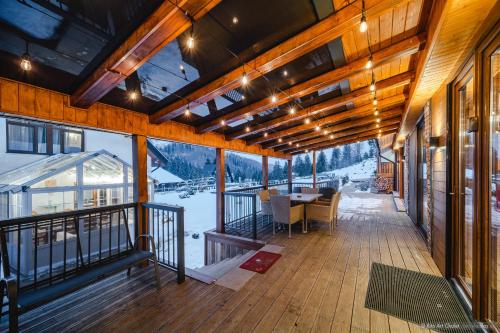 a building with a deck with a table and chairs at Rita Art Chalet Voronet in Voroneţ