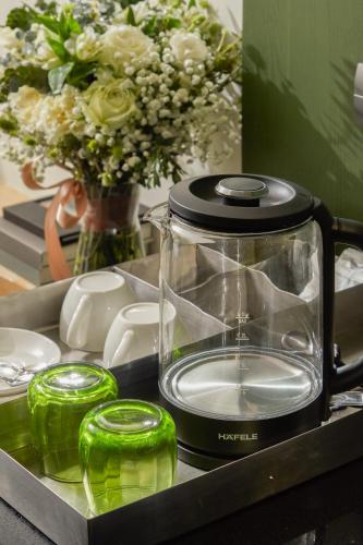 a blender sitting on a counter with a vase of flowers at Hotel Sapin in Pom Prap