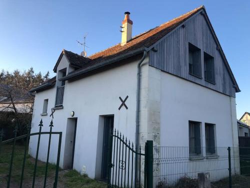 un bâtiment blanc avec une horloge sur son côté dans l'établissement Maison tourangelle au coeur du vignoble Loire Valley, à Vouvray