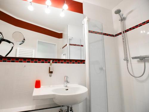 a bathroom with a sink and a shower at DORMERO Hotel Düsseldorf in Düsseldorf
