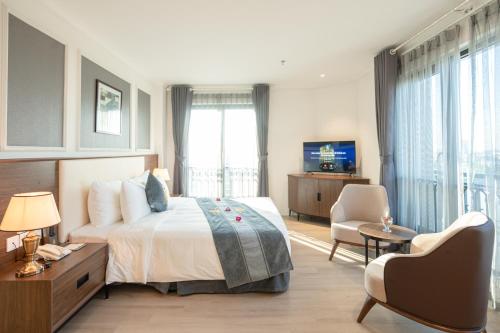 a hotel room with a bed and a tv at Rex Quang Binh Hotel in Dong Hoi