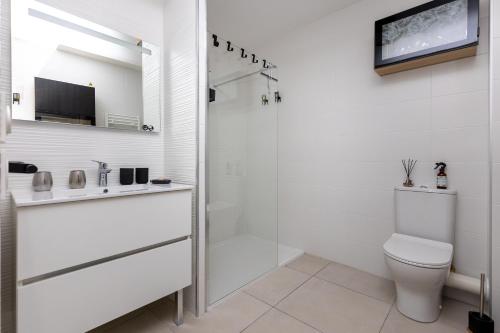 La salle de bains blanche est pourvue d'une douche et de toilettes. dans l'établissement Iri Etxea - Appt 2 chambre à Bayonne, à Bayonne