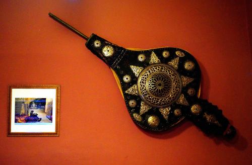 a black and gold object on a wall with a picture at Dar Omar Khayam in Tangier