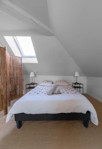 a bedroom with a large bed with a skylight at La Grande Maison Gannat in Gannat